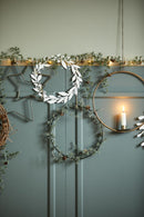 Et stemningsbillede af juleoppyntning op ad en væg, med stjerner, stearinlys og gran guirlander. 